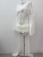 White lace dress on a mannequin against a plain background